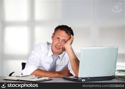 Exhausted businessman in front of computer desk