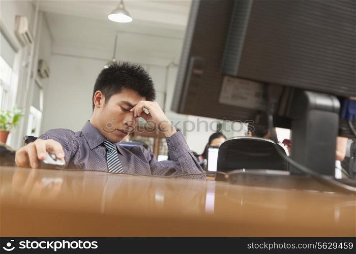 exhausted businessman sitting in front of computer