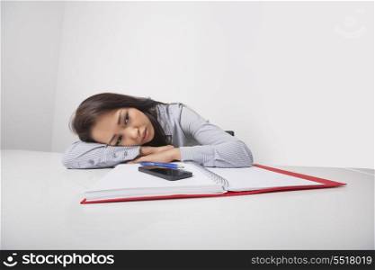Exhausted businesswoman leaning at office desk