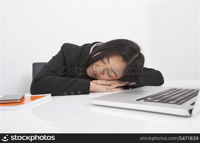 Exhausted businesswoman resting at office desk