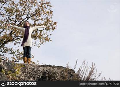 Exhilarated woman standing on rocks