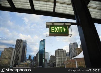Exit sign with view of buildings in downtown Sydney, Australia.