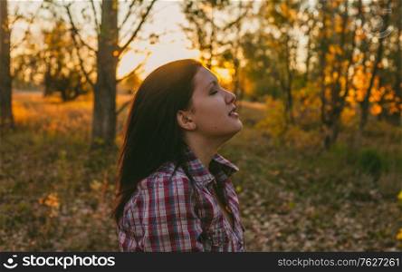 Exited girl in the woods at sunset
