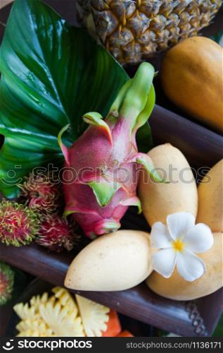Exotic fruits, juicy, natural filming. Mango, papaya, dragon fruit, rambutan, pineapple
