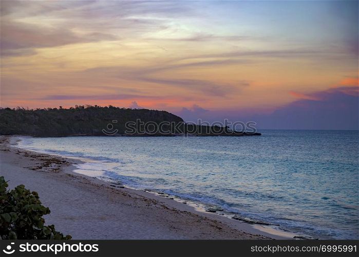 Exotic paradise of Guardalavaca beach in Cuba. Colorful sunset and peaceful ocean wave at the beach. Perfect resort for relaxing.