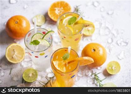 Exotic summer drinks refreshing variety of cold drinks glasses fresh fruit on ice homemade cocktail tea with mojito lemon lime orange rosemary and mint leaf, Colorful summer drink juicy