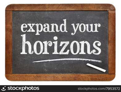 Expand your horizons - motivational text on a vintage slate blackboard