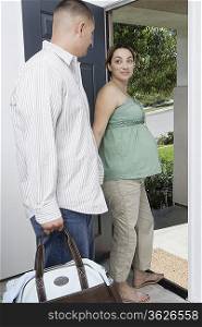 Expectant couple exiting house