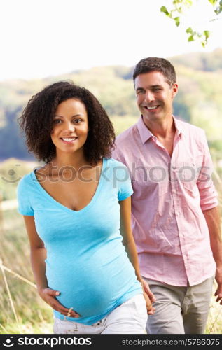 Expectant couple outdoors in countryside