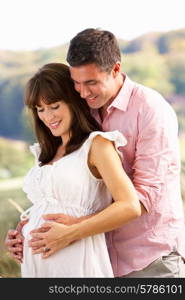 Expectant couple outdoors in countryside