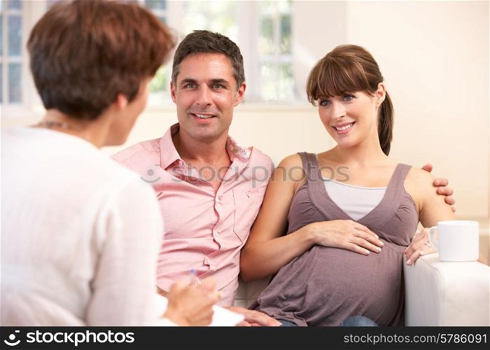 Expectant couple talking to midwife