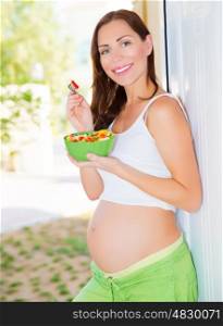 Expectant young lady eat fresh tasty salad, diet for pregnant woman, healthy lifestyle, happiness concept