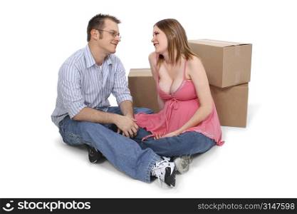 Expecting Couple Sitting Near Moving Boxes. Great detail.