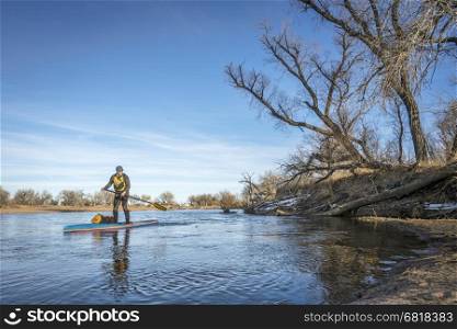 Expedition style winter stand up paddling on the South Platte RIver in eastern Colorado