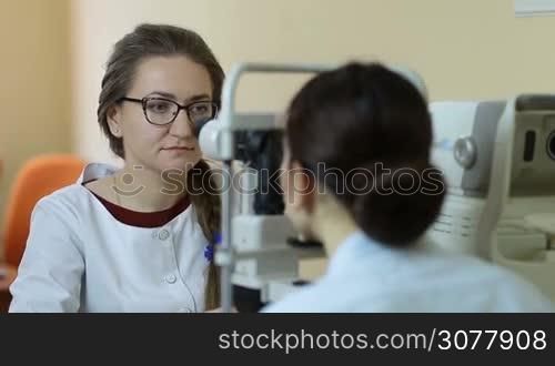 Experienced female optometrist with non contact tonometer checking patient&acute;s intraocular pressure in ophthalmology clinic. Ophthalmologist measuring intraocular pressure of patient in oculist office.