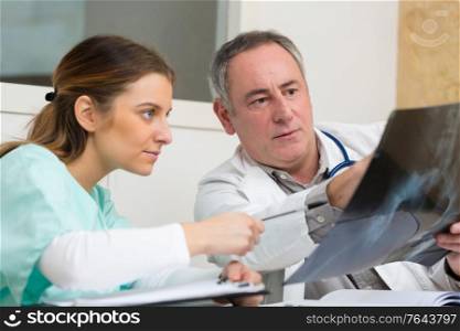 experienced male orthopedist talking to his female colleague