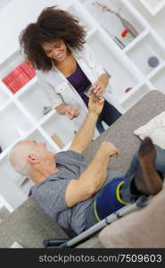 experienced physician assisting her senior man in recovery process