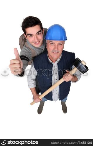 Experienced tradesman posing with his new apprentice