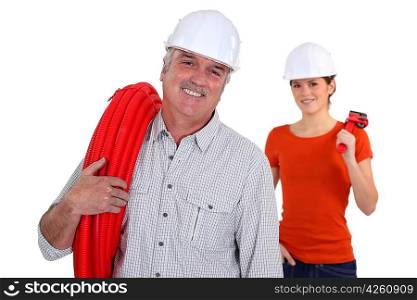 Experienced tradesman with his assistant in the background