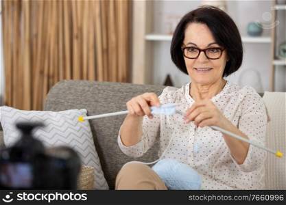 experienced woman is recording a knitting video vlog