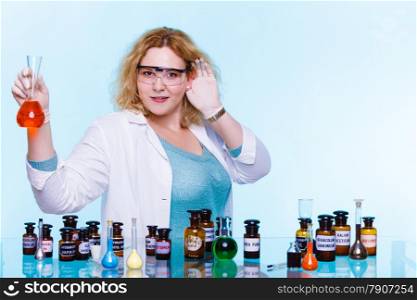Experiments in laboratory. Chemist woman or student girl, scientific researcher with chemical glassware holding hand to ear listening on blue