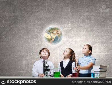 Experiments in laboratory. Cute girl and boy at chemistry lesson making tests. Elements of this image are furnished by NASA