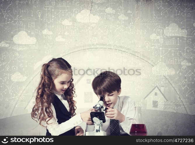 Experiments in laboratory. Cute girl and boy at chemistry lesson making tests