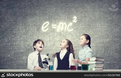 Experiments in laboratory. Cute girl and boy at chemistry lesson making tests