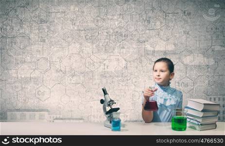 Experiments in laboratory. Cute girl at chemistry lesson making tests