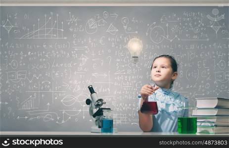 Experiments in laboratory. Cute girl at chemistry lesson making tests
