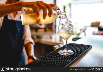 Expert barman is making cocktail alcoholic drink at night club. Professional bartender prepare cocktail