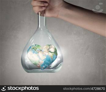 Exploration of world and planet. Close up of human hand holding test tube with Earth planet. Elements of this image are furnished by NASA
