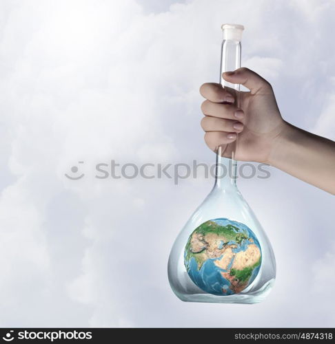 Exploration of world and planet. Close up of human hand holding test tube with Earth planet. Elements of this image are furnished by NASA