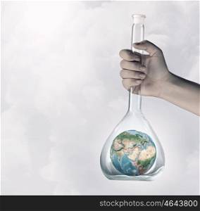 Exploration of world and planet. Hand holding glass tube with Earth planet inside. Elements of this image are furnished by NASA