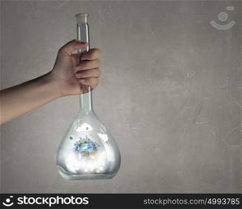 Exploration of world and planet. Hand holding glass tube with Earth planet inside. Elements of this image are furnished by NASA