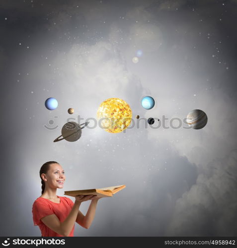 Explore space planets. Young pretty woman holding opened book and planets on pages