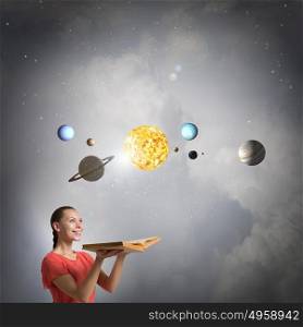 Explore space planets. Young pretty woman holding opened book and planets on pages