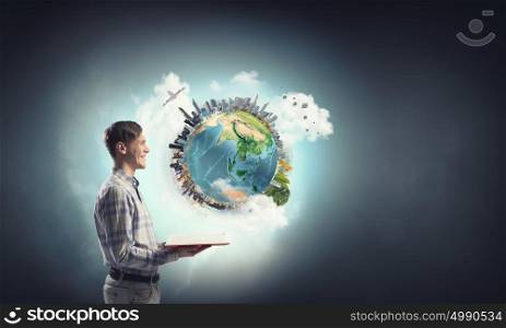 Exploring the world around us. Young man with opened book in hands. Elements of this image are furnished by NASA
