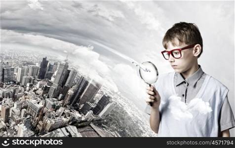 Exploring the world. Cute school boy examining objects with magnifying glass