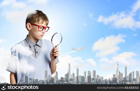 Exploring the world. Cute school boy examining objects with magnifying glass