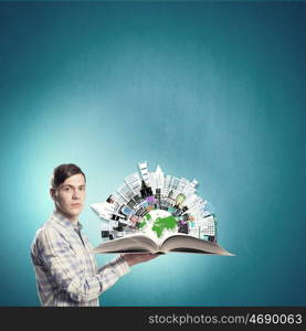 Exploring the world. Young student guy with opened book in hands