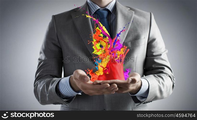 Express your creativity. Male hands holding paint splashes and icons in palms