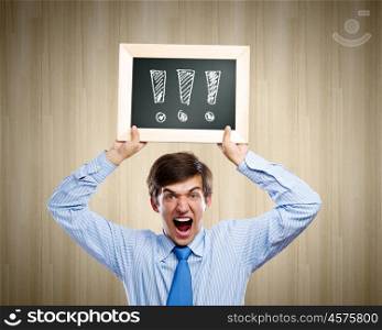 Expressing astonishment. Young anxious businessman holding frame with exclamation marks