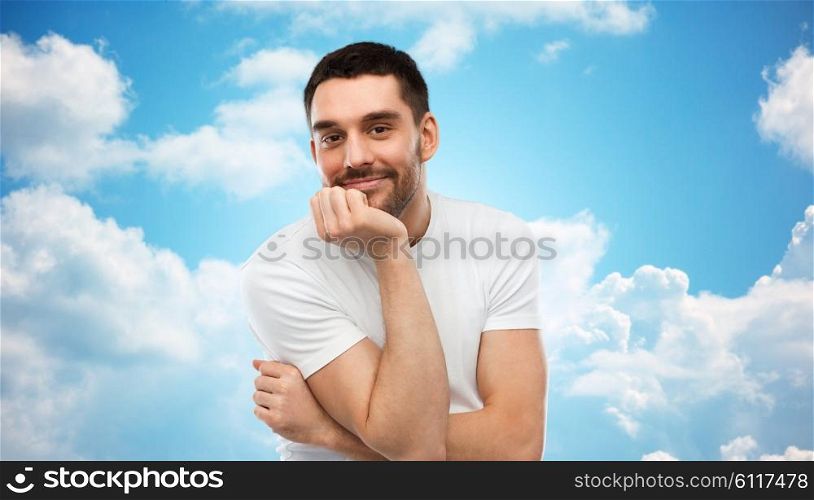 expression and people concept - happy smiling man over blue sky and clouds background. smiling man over blue sky