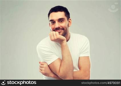 expression and people concept - happy smiling man over gray background. smiling man over gray background