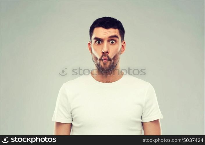 expression, fun and people concept - man with funny fish-face over gray background. man with fish-face over gray background