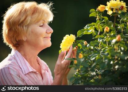 Expression. Senior Woman Model with Garden Roses. Springtime