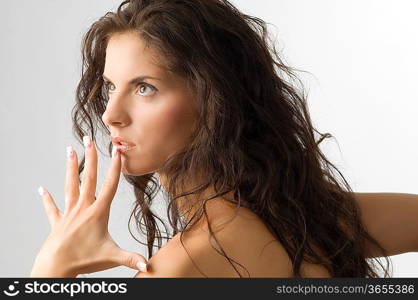 expressive cute brunette looking up and keeping an open hand near the face