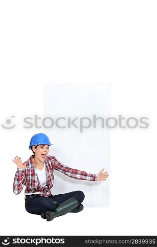 Expressive female construction worker with a blank board