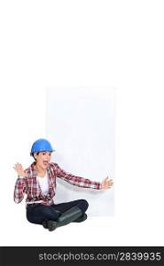 Expressive female construction worker with a blank board